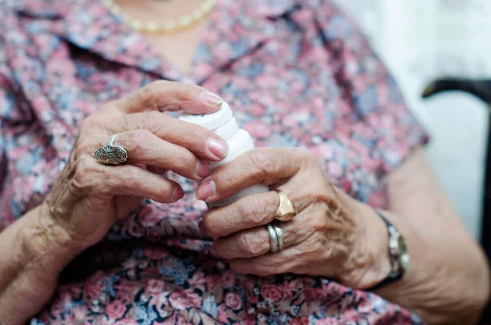 Photo of elderly woman's hands holding a pill bottle